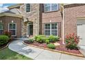 Close-up of the front entrance features brick accents, lush landscaping, and a welcoming walkway at 4590 Hastings Dr, Cumming, GA 30041