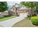 Well-maintained home featuring lush lawn, stone accents, and a two-car garage at 4590 Hastings Dr, Cumming, GA 30041