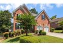 Inviting two-story brick home featuring a two-car garage and beautifully landscaped front yard at 210 Wentworth Ter, Alpharetta, GA 30022