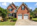 Charming two-story brick home with a well-maintained lawn and a two-car garage at 210 Wentworth Ter, Alpharetta, GA 30022
