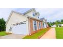Home featuring a garage, well-maintained front lawn, and manicured landscaping at 213 Whistle Way, Locust Grove, GA 30248