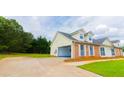 Spacious home with attached garage and well-maintained lawn, featuring charming brick accents at 213 Whistle Way, Locust Grove, GA 30248