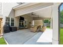 Spacious covered patio with ceiling fans, comfortable seating, and an outdoor entertainment area at 2358 Well Springs Dr, Buford, GA 30519