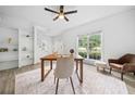 Well-lit office with built-in shelving, hardwood floors, and a large window overlooking the front yard at 5247 Hayden Farms Dr, Powder Springs, GA 30127