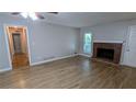 Inviting living area featuring a traditional brick fireplace, wood-look floors, and neutral paint at 1182 Demere Dr, Stone Mountain, GA 30083