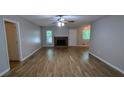Spacious living room with light gray walls, wood-look floors, and a cozy brick fireplace at 1182 Demere Dr, Stone Mountain, GA 30083