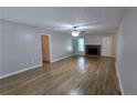 Bright living room features a decorative brick fireplace and stylish wood-look flooring throughout at 1182 Demere Dr, Stone Mountain, GA 30083