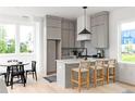 A stylish kitchen features gray cabinets, a center island and a breakfast bar at 1230 Mado Loop, Chattahoochee Hills, GA 30268
