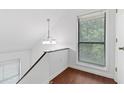 Bright hallway with wood floors, large window, and modern chandelier at 1301 Cumberland Se Ct, Smyrna, GA 30080