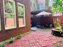 Cozy backyard featuring a private patio with umbrella, seating, and brick-lined garden at 5605 Waters Edge Trl, Roswell, GA 30075