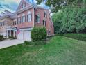 Charming brick townhome featuring a two-car garage and lush landscaping at 5605 Waters Edge Trl, Roswell, GA 30075
