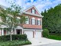 Charming brick townhome featuring a two-car garage and beautiful landscaping at 5605 Waters Edge Trl, Roswell, GA 30075