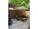 Private outdoor patio featuring a grill, seating under a pergola, and a sun umbrella at 5605 Waters Edge Trl, Roswell, GA 30075