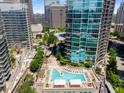 Aerial view of a luxurious pool surrounded by high-rise buildings and well-manicured landscaping at 1080 Peachtree Ne St # 608, Atlanta, GA 30309