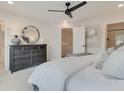 Cozy bedroom featuring a ceiling fan, stylish dresser with round mirror, and comfortable bed with plush pillows at 4814 Floydwood Ln, Mableton, GA 30126