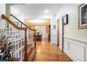 Elegant foyer with hardwood floors, a staircase with wooden railing, and views into the dining room at 725 Windsor Place Sw Cir, Grayson, GA 30017