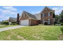Traditional brick home features a manicured front lawn, attached garage, and classic design elements at 725 Windsor Place Sw Cir, Grayson, GA 30017