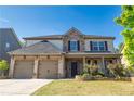 Charming brick and stone two-story home featuring a well-manicured lawn and a two-car garage at 4750 Sabino Bnd, Cumming, GA 30040