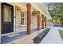 Inviting front porch with brick columns, hanging plants, and a stylish entrance, creating a welcoming exterior at 4125 Hickory Dr, Powder Springs, GA 30127