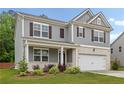 Two-story home with gray siding, brick accents, two-car garage, and well-manicured landscaping at 4827 Golden Finch Ln, Powder Springs, GA 30127