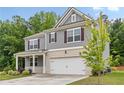 Charming two-story home features gray siding, brick accents, and a two-car garage at 4827 Golden Finch Ln, Powder Springs, GA 30127