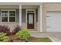 Inviting front entrance with a glass-paneled door, white columns, and landscaped greenery at 4827 Golden Finch Ln, Powder Springs, GA 30127