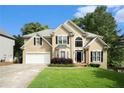 Beautiful two-story home with a lush green lawn, two-car garage, and a charming front entrance at 5215 Tealing Ne Dr, Roswell, GA 30075