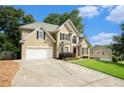 Charming two-story home with a sprawling green lawn, attached garage, and a pleasant front entrance at 5215 Tealing Ne Dr, Roswell, GA 30075
