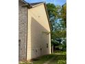 View of home's side yard featuring brick and siding exterior and small lawn at 11813 Lovejoy Crossing Blvd, Hampton, GA 30228