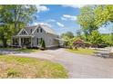 Charming gray home with metal roof, inviting front porch, well-manicured lawn and a red outbuilding on sunny day at 527 Main St, Suwanee, GA 30024