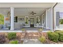 Inviting front porch with comfortable seating, ceiling fans, and brick steps at 527 Main St, Suwanee, GA 30024