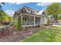 Charming gray home with a covered front porch, manicured lawn, and beautiful landscaping at 527 Main St, Suwanee, GA 30024