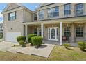 Inviting front porch featuring white columns and a walkway with lush green landscaping at 7328 Vigo Dr, Lithonia, GA 30058