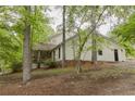 Inviting home tucked among mature trees and featuring a covered porch, creating a serene, private setting at 8315 Nicholson Rd, Cumming, GA 30028