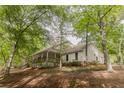 Quaint home set amongst mature trees featuring a charming, covered front porch, ideal for outdoor relaxation at 8315 Nicholson Rd, Cumming, GA 30028