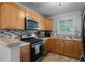 Well-lit kitchen featuring stainless steel appliances, a mosaic backsplash, and ample wooden cabinetry at 105 Olde Mill Ln, Norcross, GA 30093