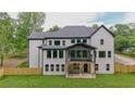 Backyard view of this home, featuring a covered porch, fenced yard and a well-maintained lawn at 2977 N Bogan Rd, Buford, GA 30519