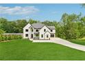 Beautiful two-story home with a well manicured lawn, a black roof, and a long concrete driveway at 2977 N Bogan Rd, Buford, GA 30519
