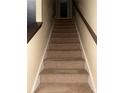 Carpeted staircase with wooden handrail and neutral-colored walls at 4752 Browns Mill Ferry Rd, Lithonia, GA 30038