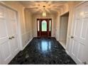 Welcoming foyer featuring dark tile flooring and a decorative front door at 5346 Light Cir, Norcross, GA 30071