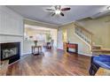 Living room boasting a fireplace, wood floors, and a staircase leading to upper levels with a view into the dining area at 10900 Wittenridge Dr # L6, Alpharetta, GA 30022