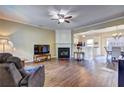 Spacious living room featuring hardwood floors, a cozy fireplace, and seamless flow to the adjacent dining area at 10900 Wittenridge Dr # L6, Alpharetta, GA 30022