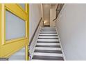 Entryway featuring stairs with wooden treads, white risers, and a yellow front door at 1149 Ansel Nw Ln, Atlanta, GA 30318