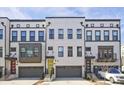 Charming townhome exterior featuring gray garages, a yellow front door, and red door with traditional brick and siding at 1149 Ansel Nw Ln, Atlanta, GA 30318