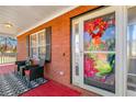 Inviting front porch with red painted floor and brick walls with black seating and festive decorations on the front door at 120 Aspen Forest Dr, Covington, GA 30016