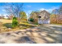 Home featuring a driveway leading to a two-car garage and a spacious backyard, perfect for outdoor activities at 120 Aspen Forest Dr, Covington, GA 30016