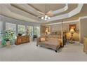 Spacious main bedroom featuring a tray ceiling, sitting area, and large windows at 3735 Duckcove Way, Cumming, GA 30041