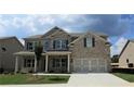 Beautiful two-story home with a brick and siding exterior, a well-manicured lawn, and two-car garage at 1107 Kingston Hill Dr, Loganville, GA 30052