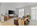 Bright living room with modern furniture, a large TV, and sheer curtains for natural light at 560 Dutch Vly # 2313, Atlanta, GA 30324
