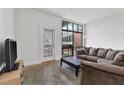 Spacious living room featuring concrete floors and a sliding glass door to a balcony at 89 Mangum St # 210, Atlanta, GA 30313